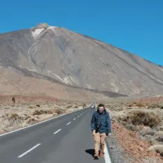 Mężczyzna idzie drogą w kierunku najwyższego szczytu Hiszpanii, wulkanu Teide, na Teneryfie.