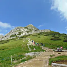 Tłum turystów wspina się kamienistym szlakiem na szczyt Giewontu, by zobaczyć, ile ma Giewont.