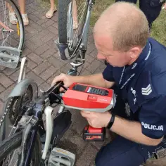 Policjant dokonuje rejestracji roweru za pomocą specjalnego urządzenia.