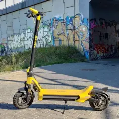 Żółta hulajnoga elektryczna Xrider stoi na chodniku. Czy hulajnogą elektryczną można jeździć po chodniku? To pytanie nurtuje wielu.