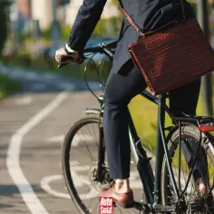 Biznesmen na rowerze, mimo że ścieżka rowerowa jest wyraźnie oznaczona, jedzie po chodniku. Może to oznaczać zakaz jazdy rowerem w tym miejscu.