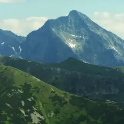 Majestatyczny szczyt w Tatrach Wysokich 2494 m, otoczony zielonymi zboczami i skalistymi graniami.