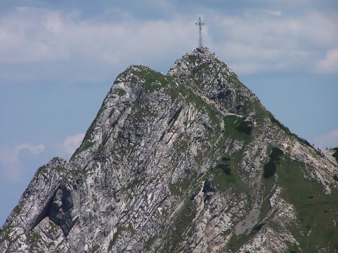 Szczyt Giewontu z krzyżem i turystami. Warto wiedzieć, ile ma Giewont, by docenić jego majestat.